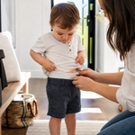 Parent checking the waistband fit of a toddler’s nappy pants before leaving home